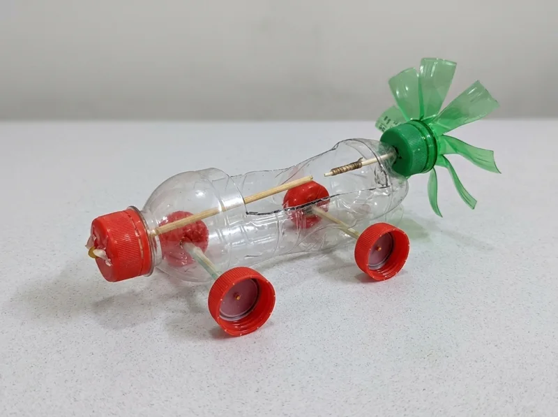 Carro hecho con una botella plástica y ruedas de tapitas