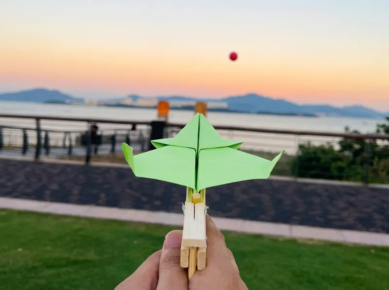 Lanzador de aviones de papel hecho con palitos y una pinza